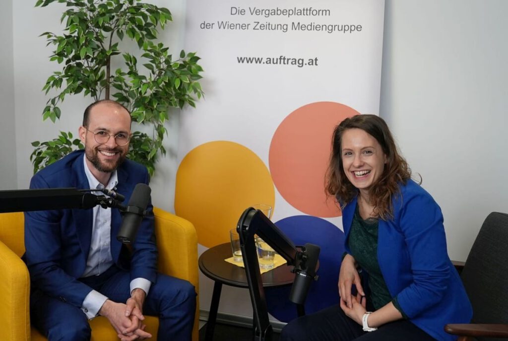Titelbild für Blogbeitrag, eine Person und eine Person, die auf Stühlen mit Podcast-Mikrofonen sitzen