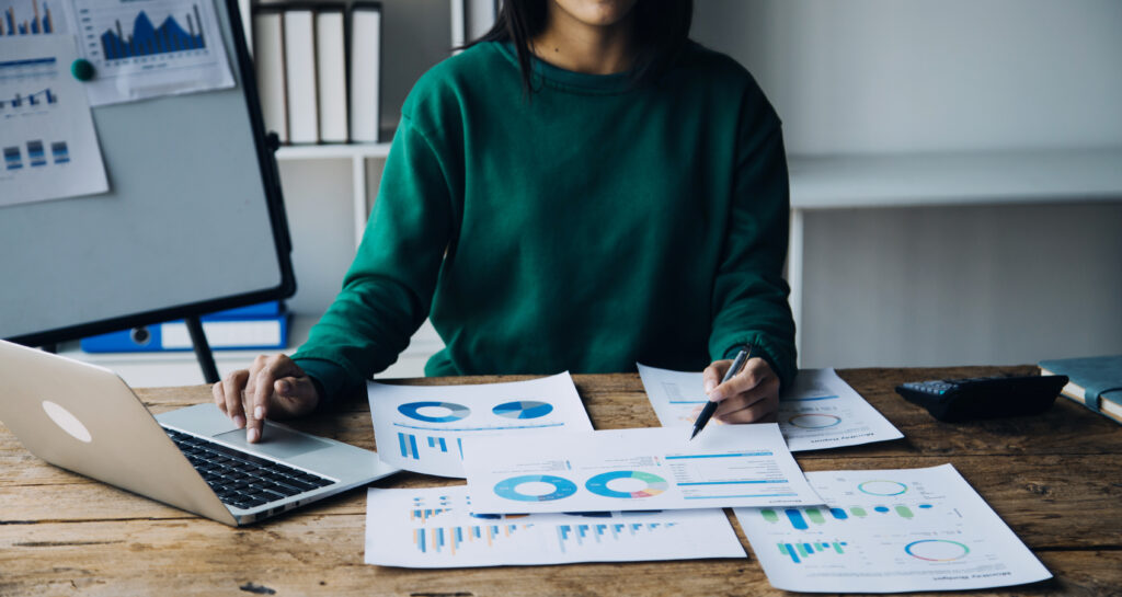 Person wertet Geschäftszahlen am Laptop aus.